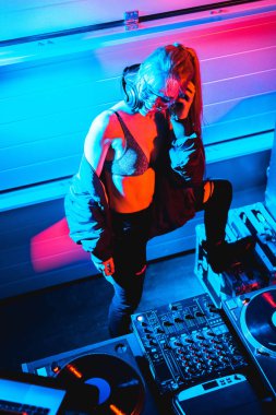 Genel gider mutlu dj kulaklık gece kulübünde dokunmadan sarı saçlı kız görünümünü