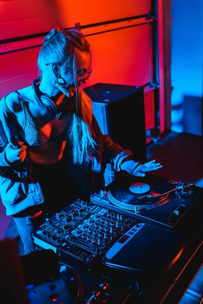 Happy Blonde Woman Holding Bottle While Touching Vinyl Record Nightclub — Stock Photo, Image