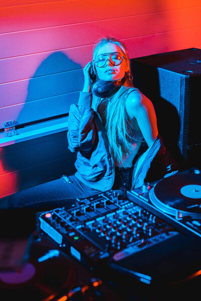 dj woman listening music in headphones while sitting with closed eyes