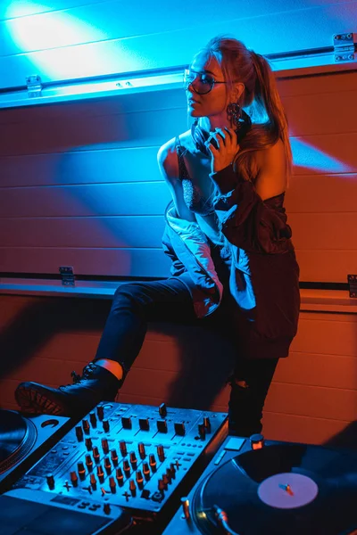 çekici sarışın dj kız ayakta ve kulaklık gece kulübünde dokunmadan gözlük