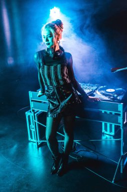 güzel dj kız dumanlı gece kulübünde dj ekipmanları yanında ayakta