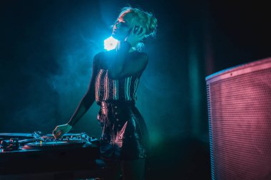 müzik dinleme ve kulaklık dumanlı gece kulübünde dokunmadan sarışın kadınla mutlu dj