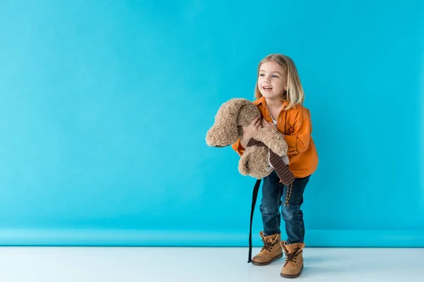 Leende Och Bedårande Kid Innehar Nallebjörn Blå Bakgrund — Stockfoto