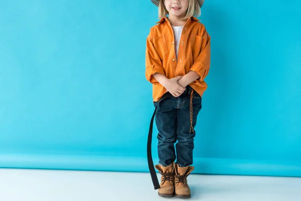 Abgeschnittene Ansicht Des Kindes Jeans Und Orangefarbenem Hemd Auf Blauem — Stockfoto