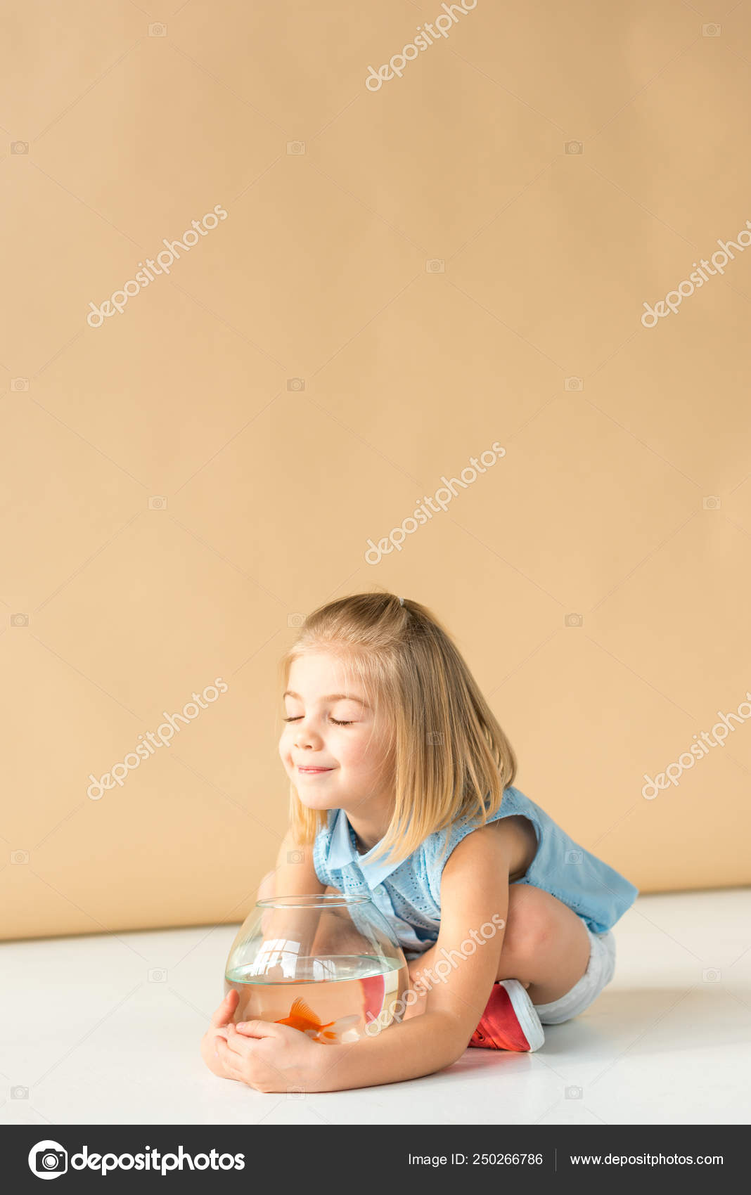 Niedliches Kind Sitzt Mit Überkreuzten Beinen Und Hält Fischschale Auf