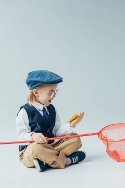 sürpriz çocuk ile otururken bacak bacak ve kırmızı tutarak ve net Kelebek kelebek
