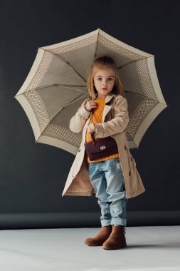 sürpriz çocuk yağmurluk ve şemsiye tutan ve kameraya bakarak kot 