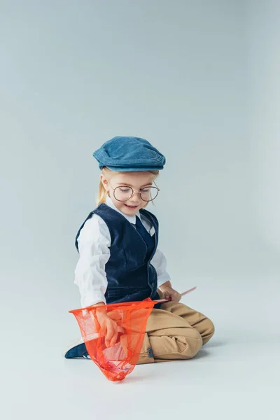 Cute Kid Sitting Floor Looking Red Butterfly Net Grey Background — Stock Photo, Image