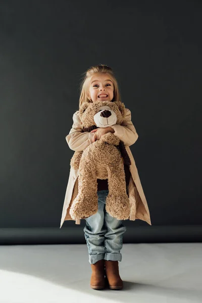 Niño Feliz Lindo Gabardina Jeans Sosteniendo Oso Peluche Sobre Fondo — Foto de Stock