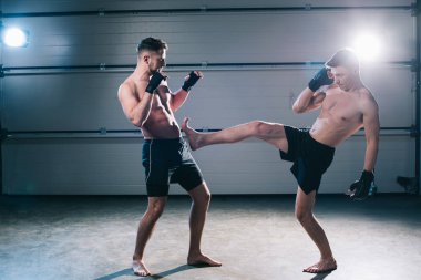 kaslı çıplak ayakla mma savaşçı tekme sportif bir rakiple bacak yan görünüm
