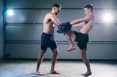Eğitim sırasında başka bir sporcu ile tekme pratik atletik kas mma savaşçı