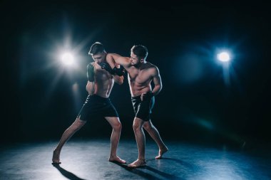 mma fighter punching another sportsman during muay thai training clipart