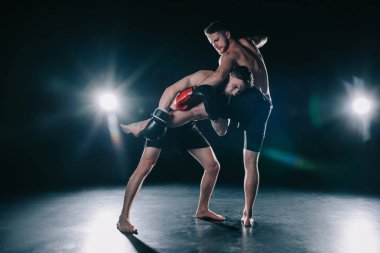 Boks eldivenleri ona tekme sporcu ise başka bir clinching yalınayak güçlü kas mma savaşçı
