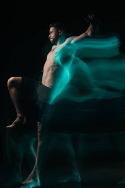 Yeşil ışıkta siyah üzerine atlama sportif kas mma savaşçı uzun pozlama