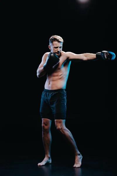 肌肉赤脚运动拳击手在拳击手套做打孔孤立的黑色 — 图库照片