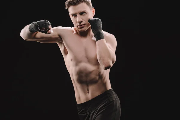 强壮的运动肌肉运动员在绷带做冲床孤立的黑色 — 图库照片