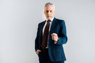kameraya bakarken parmak ile işaret yakışıklı olgun işadamı gri izole