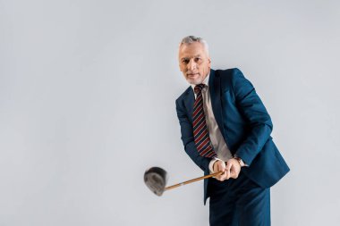 golf kulübü tutarken oynarken gri izole neşeli olgun işadamı seçici odak 