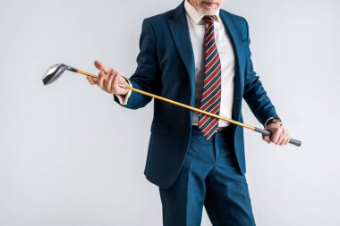 kırpılan golf club gri izole tutan takım elbiseli olgun adam görünümünü
