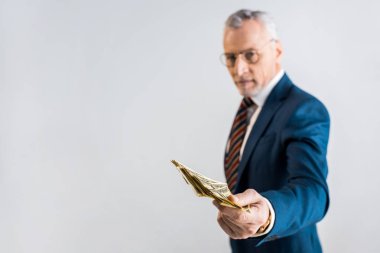Doları banknot gözlük ve formal giyim gri izole olgun iş adamı elinde seçici odak 