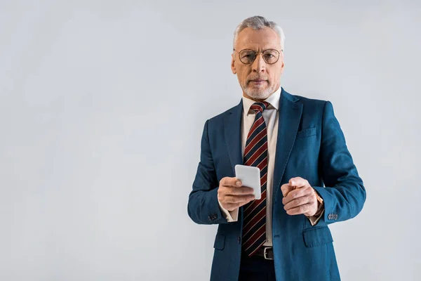 Reifer Geschäftsmann Anzug Hält Smartphone Der Hand Und Zeigt Mit — Stockfoto