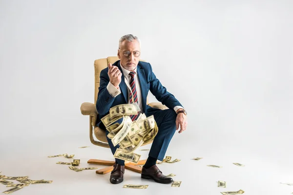 Selective Focus Serious Mature Businessman Sitting Armchair Throwing Air Dollar — Stock Photo, Image