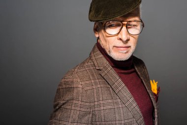 dalgın ve şık şapka ve gözlük gri üzerinde duran adam Olgun