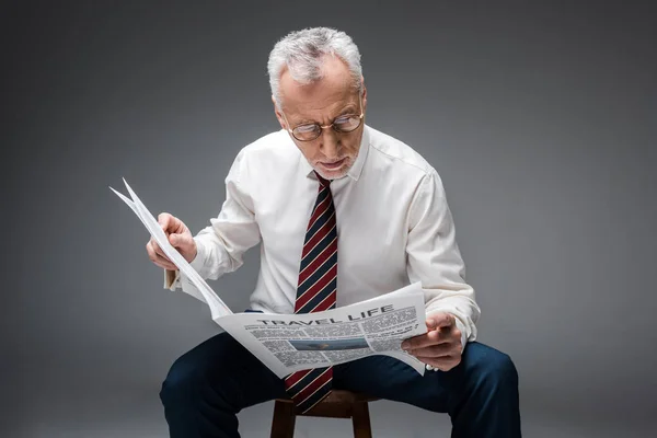 Reifer Geschäftsmann Anzug Liest Reisezeitung Auf Grau — Stockfoto