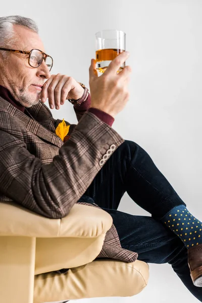 Uomo Maturo Pensieroso Seduto Poltrona Guardando Vetro Whisky Isolato Grigio — Foto Stock