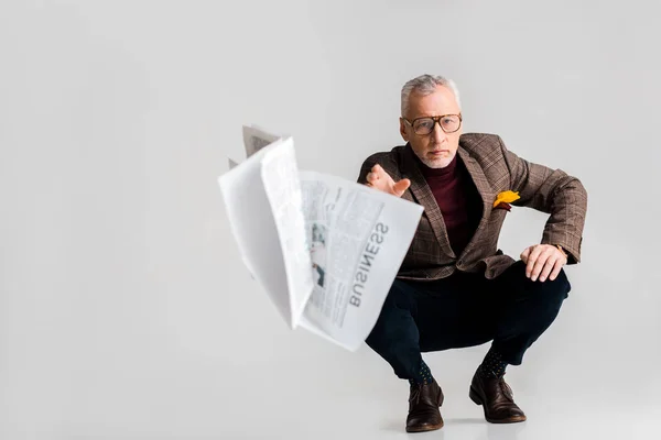 Selective Focus Mature Man Throwing Air Business Newspaper While Sitting — Stock Photo, Image