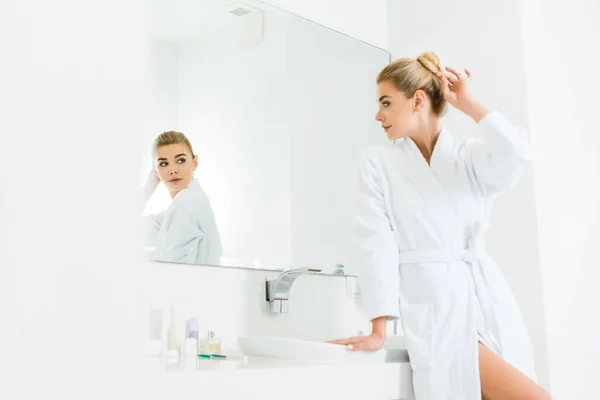 Selective Focus Attractive Blonde Woman White Bathrobe Looking Mirror Bathroom — Stock Photo, Image