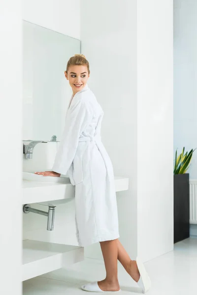 Hermosa Sonriente Mujer Albornoz Blanco Zapatillas Mirando Hacia Otro Lado — Foto de Stock