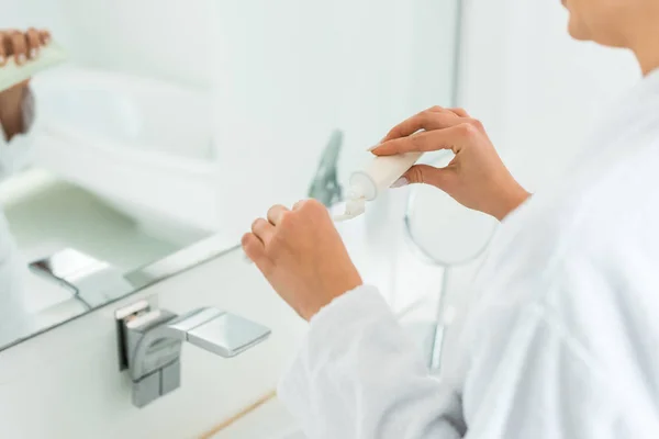 女性浴室に歯ブラシに歯磨き粉を適用することの選択と集中 — ストック写真