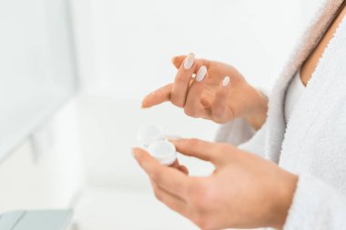 Kontakt lens banyoda tutan genç yetişkin kadın seçici odak 