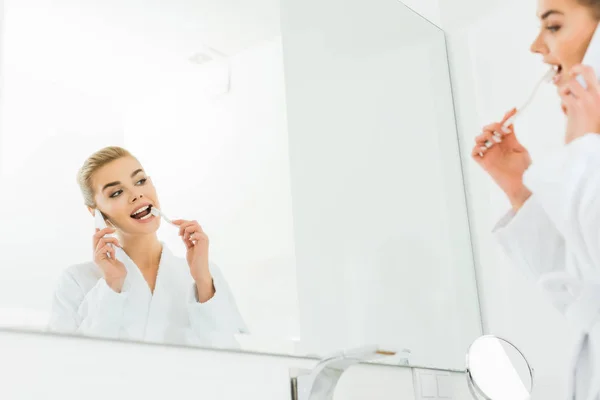 Selective Focus Woman White Bathrobe Brushing Teeth Talking Smartphone — Stock Photo, Image