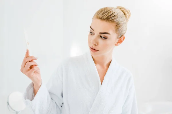 Mulher Atraente Loira Roupão Banho Branco Segurando Arquivo Unhas Banheiro — Fotografia de Stock