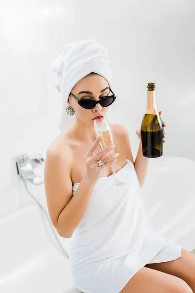 Attraktiv Kvinna Solglasögon Och Handdukar Håller Flaskan Och Dricka Champagneglas — Stockfoto