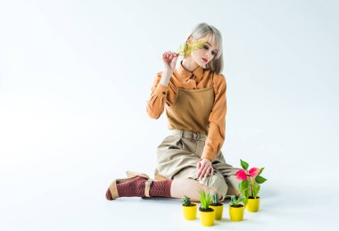 oturma ve beyaz yaprak ve çiçek tencere fern ile poz güzel şık kız