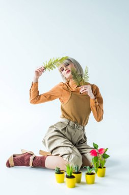 Fern ile poz güzel şık kız saksı beyaz üzerinde bırakır.