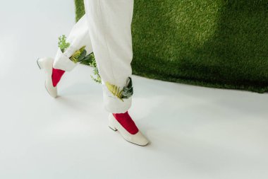 yeşil yaprakları ve şık ayakkabılar beyaz pantolon içinde kadın düşük bölümü 