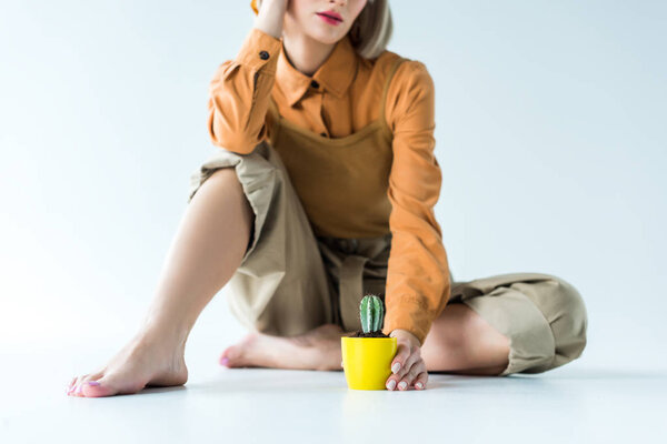 cropped view of stylish girl with cactus plant on white 