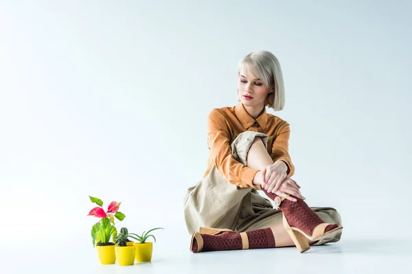 コピー スペースと白で植木鉢のそばに座って美しいスタイリッシュな女の子 — ストック写真