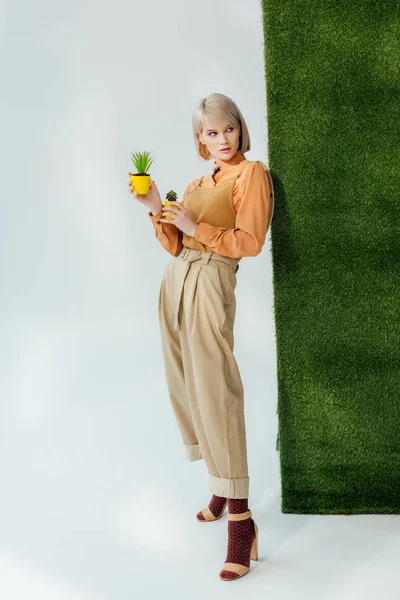 Bela Menina Loira Elegante Segurando Vasos Flores Cinza Com Grama — Fotografia de Stock