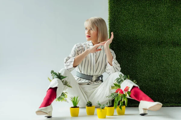 Hermosa Chica Elegante Sentado Cerca Macetas Gris Con Hierba Verde — Foto de Stock