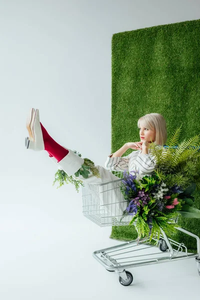 Schöne Stilvolle Mädchen Sitzen Einkaufswagen Mit Blumen Auf Weiß Mit — Stockfoto