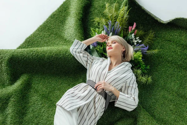 Красива Модна Дівчина Лежить Штучній Траві Папороті Квітами — стокове фото