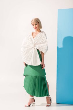 Kağıt elbiseleri mavi ve beyaz poz kameraya bakıyor güzel moda kız
