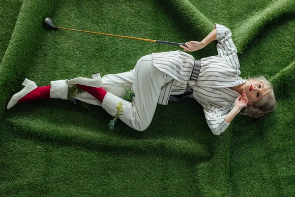 Bela Menina Elegante Deitado Com Clube Golfe Grama Artificial Olhando — Fotografia de Stock