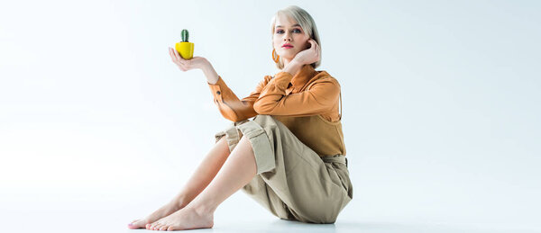 panoramic shot of beautiful stylish girl with flower pots looking at camera isolated on white