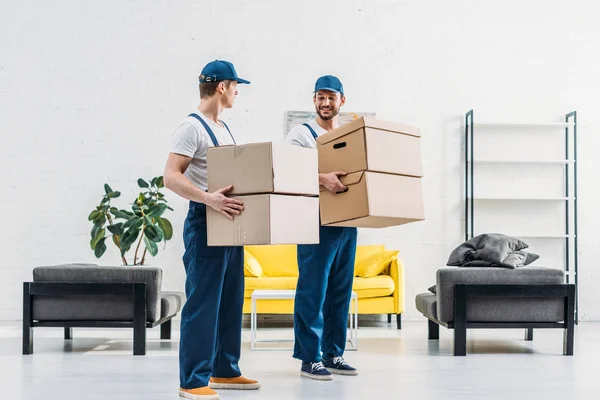 Two Movers Uniform Carrying Cardboard Boxes Modern Apartment — Stock Photo, Image